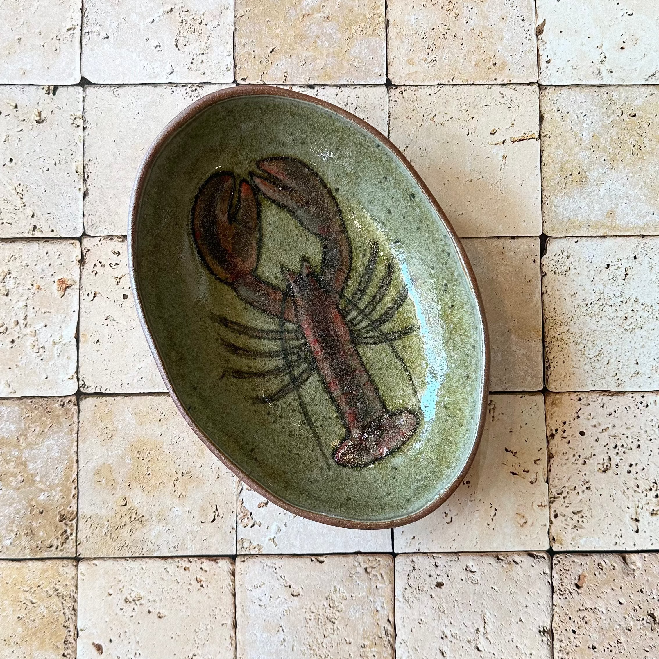 Ceramic plate with a lobster design on a tiled wall