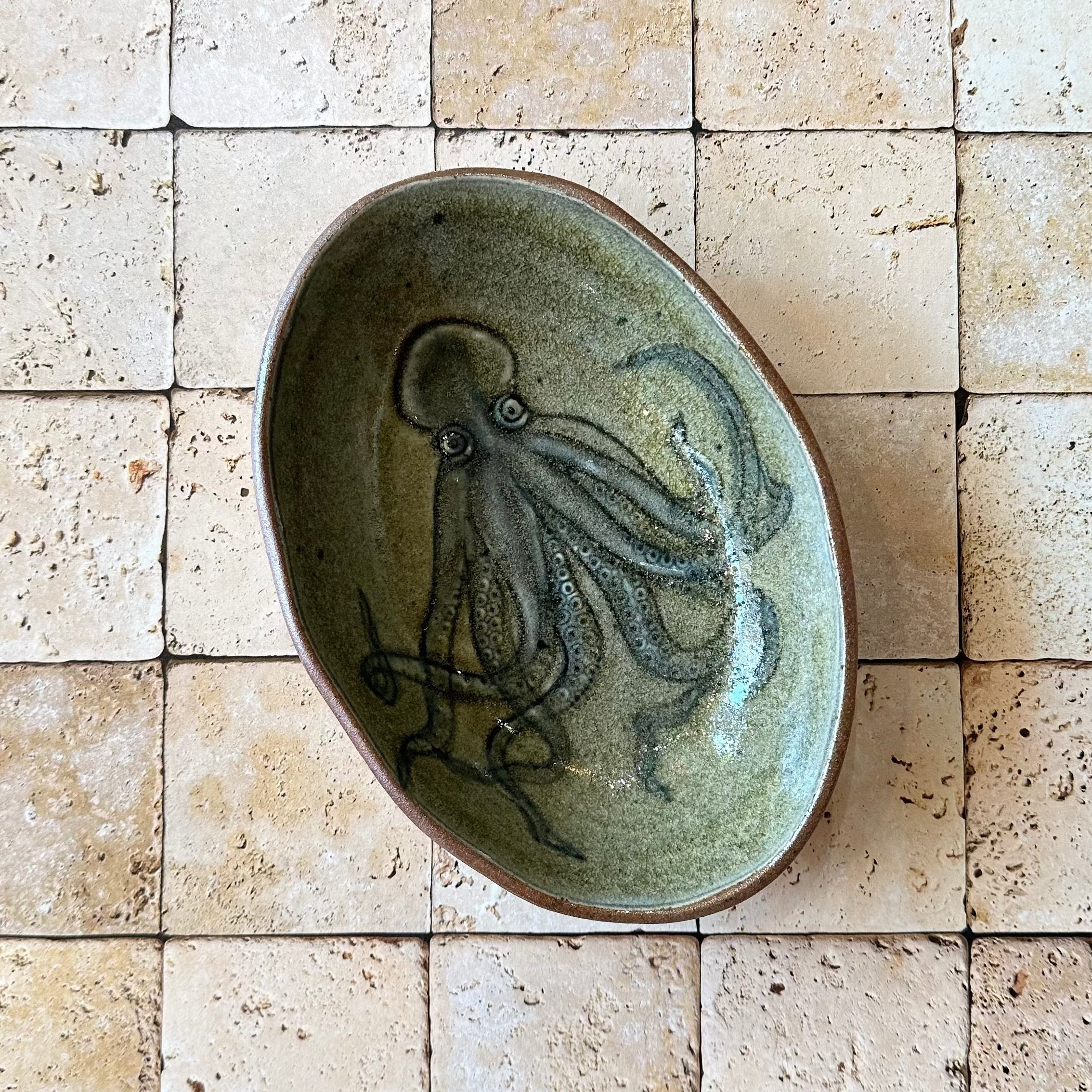 Ceramic plate with an octopus design on a tiled wall